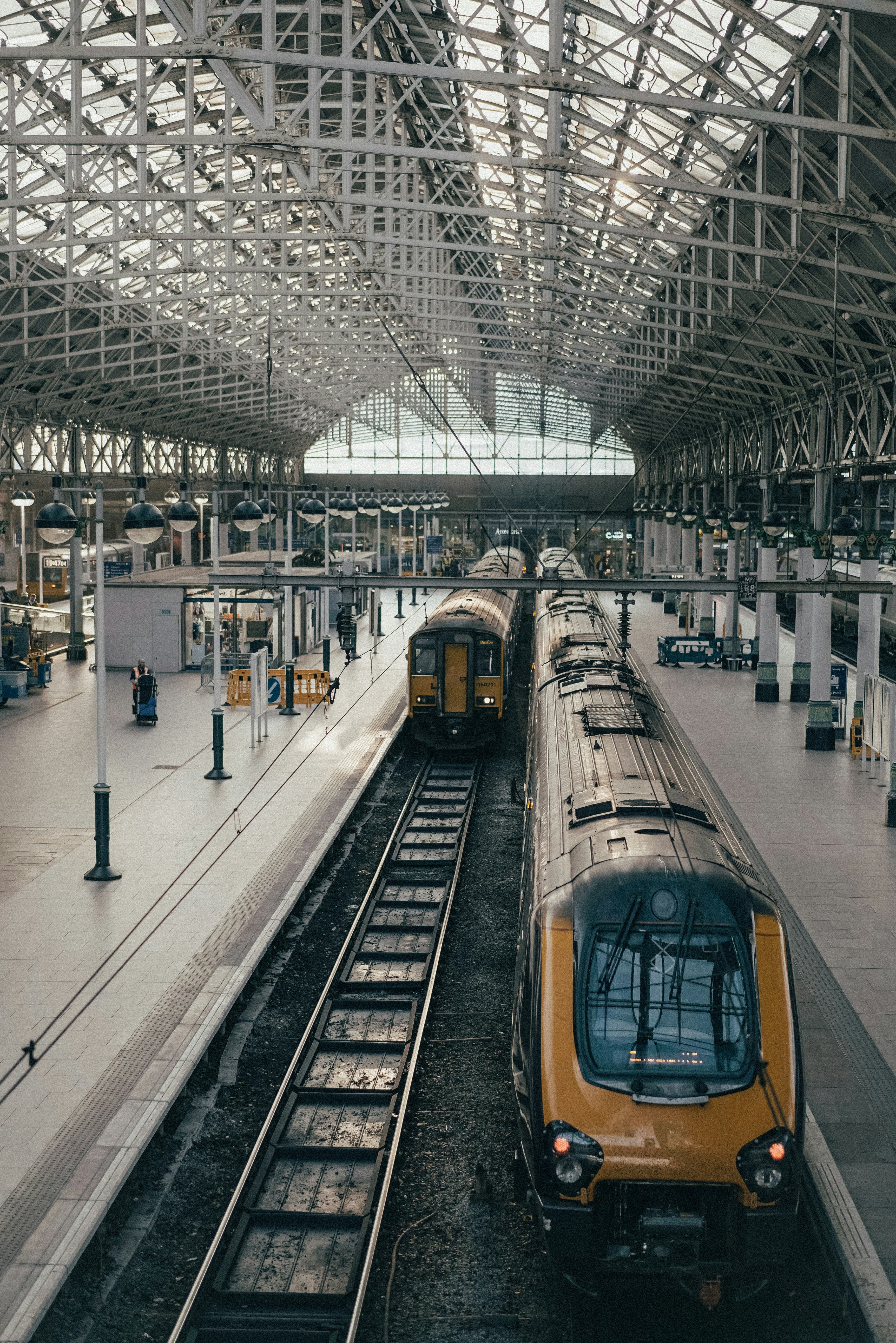 Platforms and trains under the vaulted iron roof of a large UK railway station